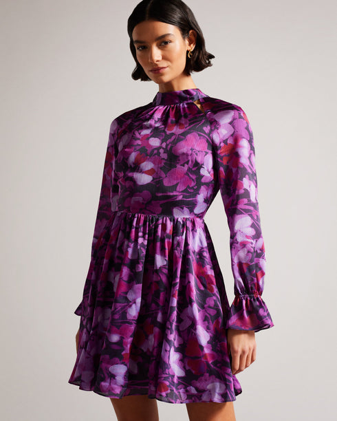 SAMMIEH-Dresses-Hello, gorgeous. SAMMIEH is the ultimate in flirty flower power. Featuring frills, cut outs and a vibrant floral print, this mini dress is just as at home with chunky boots as it is with sky high heels.The fabric of this product is made of 100% recycled polyester. Using recycled polyester helps divert plastic waste from ending in landfills and helps us to reduce our dependancy on virgin materials. Mini dress Floral print Fit and flare Long sleeved with frill cuffs High neck Zip fastening Tie